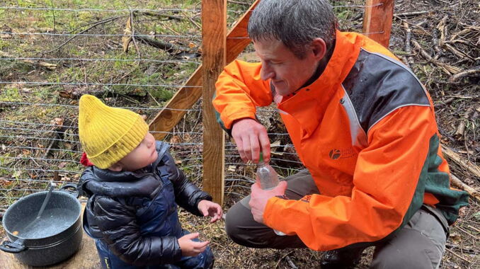 Förster mit kleinem Jungen bei Pflanzaktion