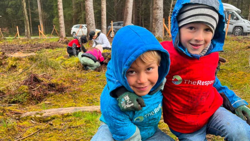 2 Jungen pflanzen einen Kids4Roots Baumsetzling im Wald