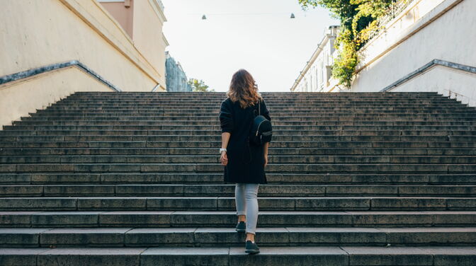 Frau geht Treppen empor