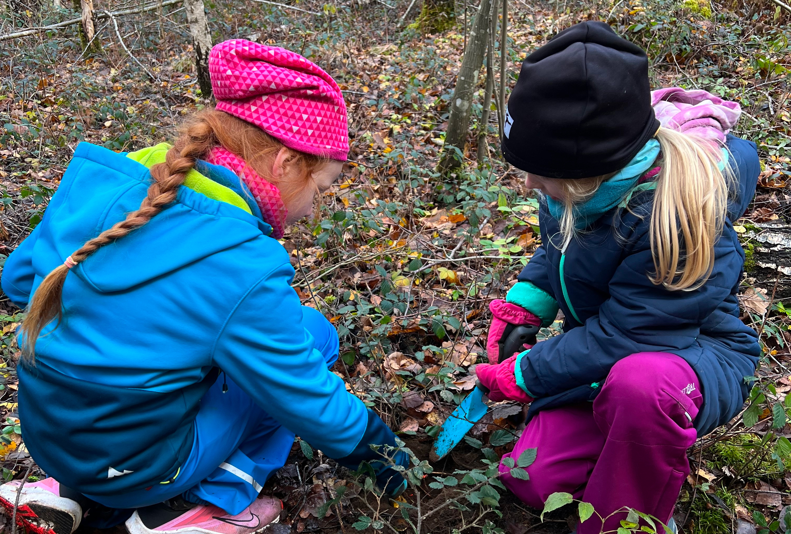 2 Grundschuelerinnen pflanzen einen Baumsetzling